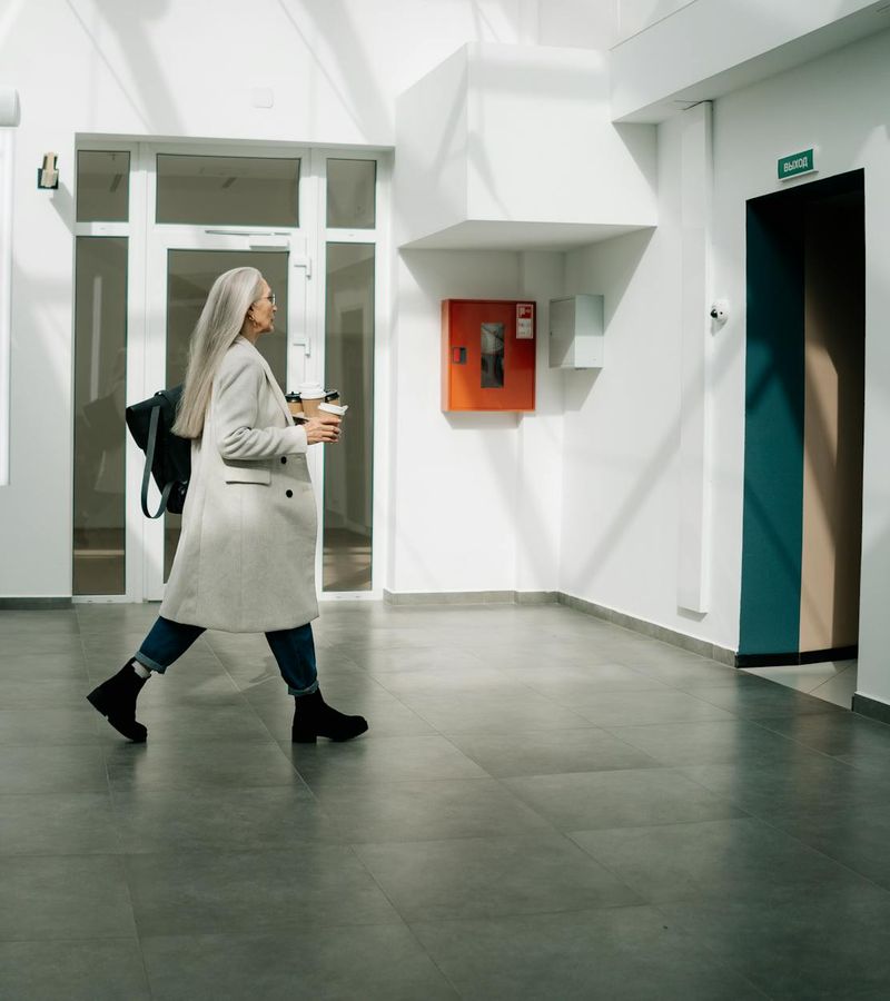 Woman performing a fluid cardio movement in a bright, minimalist space.